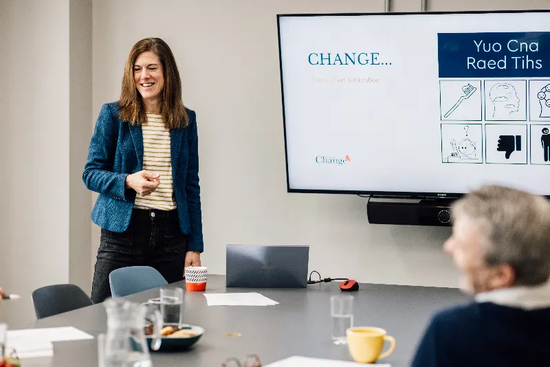 Lisa presenting to a group beside a screen about change